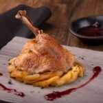 Confit de pato con manzana caramelizada y salsa de frutos rojos (ración 250grs. aprox.)